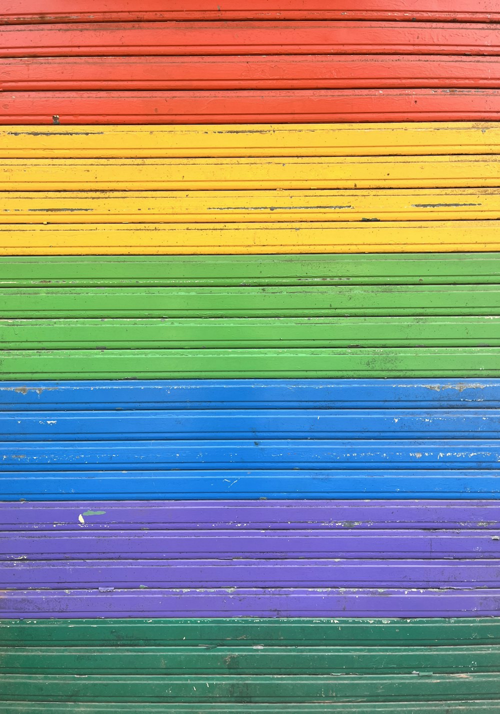 a multicolored wall with a bench in front of it