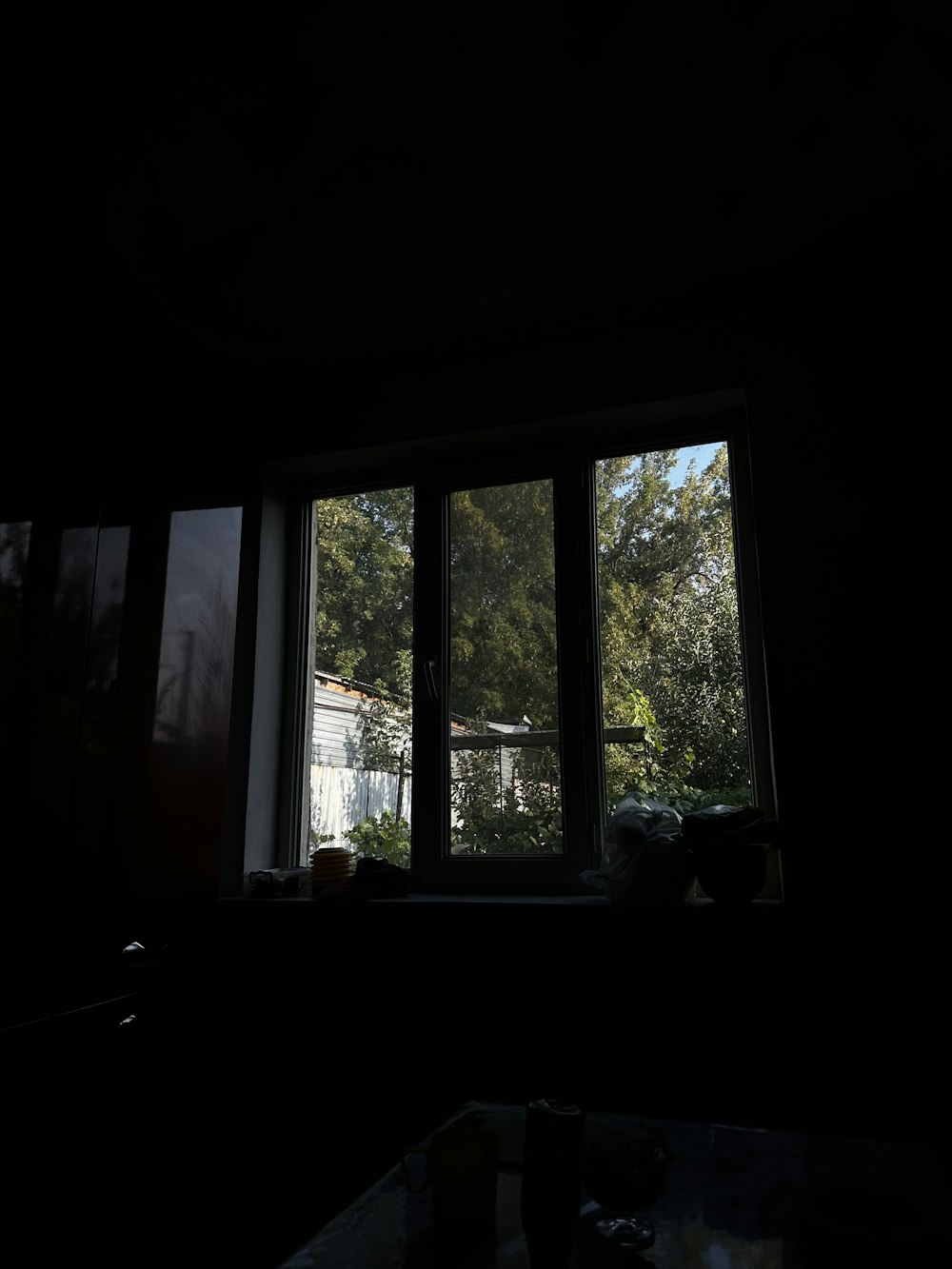 a window in a dark room with a view of a house