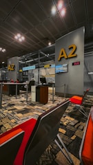 an airport terminal with a lot of chairs and desks