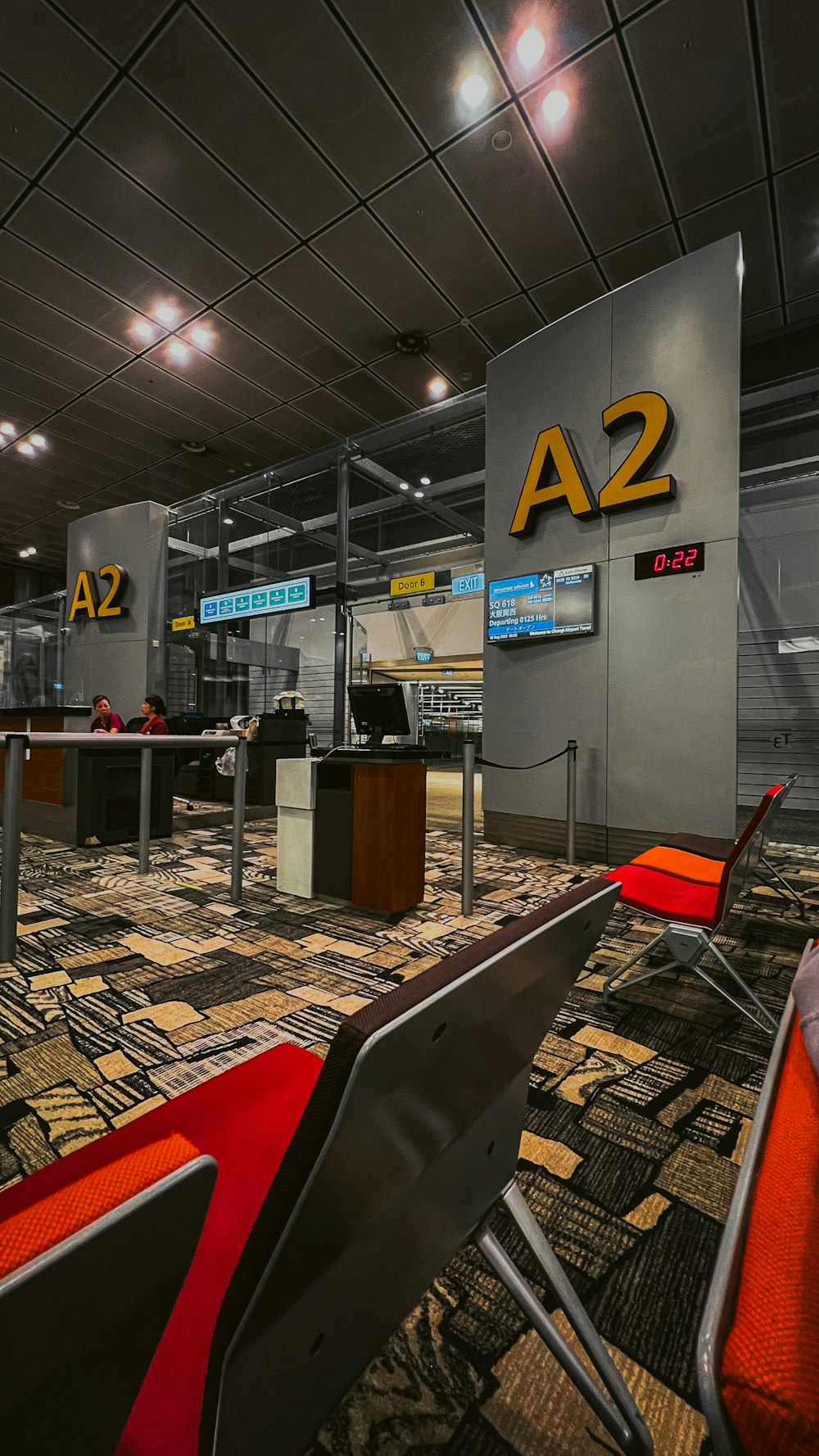 an airport terminal with a lot of chairs and desks