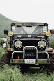 Local driver smiling next to a 4x4 jeep ready for adventure.
