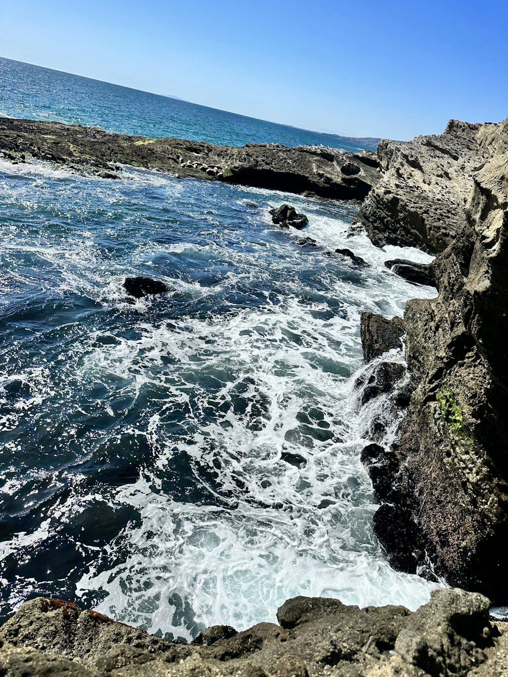 a view of the ocean from a rocky cliff