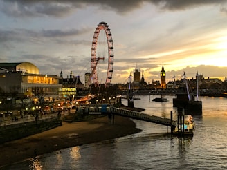 Sunset view over the Thames with softly glowing city lights and the silhouette of the London Eye