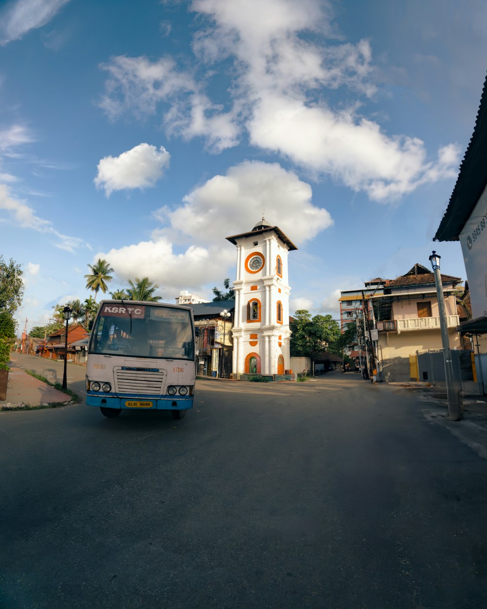 a bus driving down a street next to a tall building