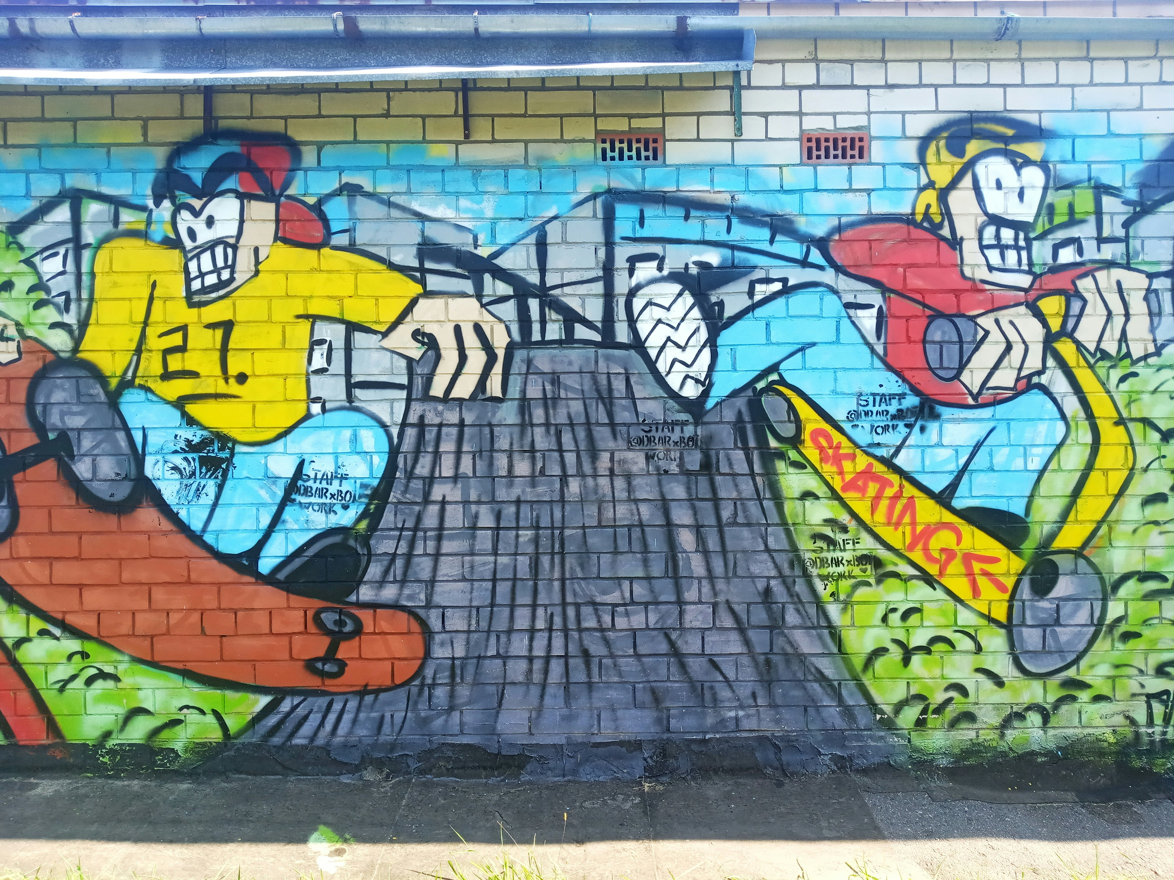 un muro con un dipinto di un uomo che cavalca uno skateboard