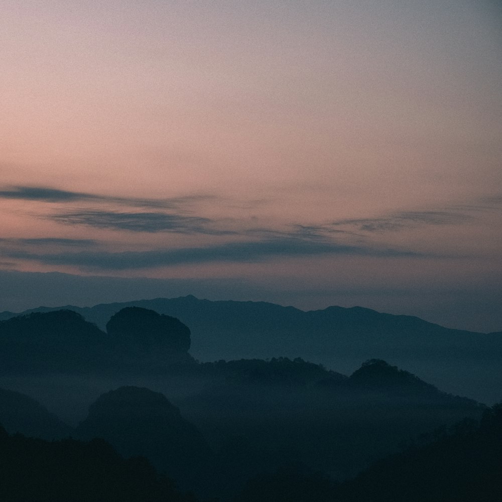 a plane flying over a mountain range at dusk