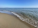 a sandy beach with waves coming in to shore