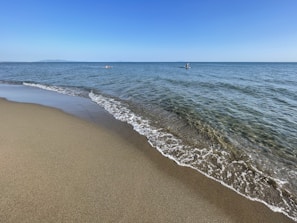 a sandy beach with waves coming in to shore