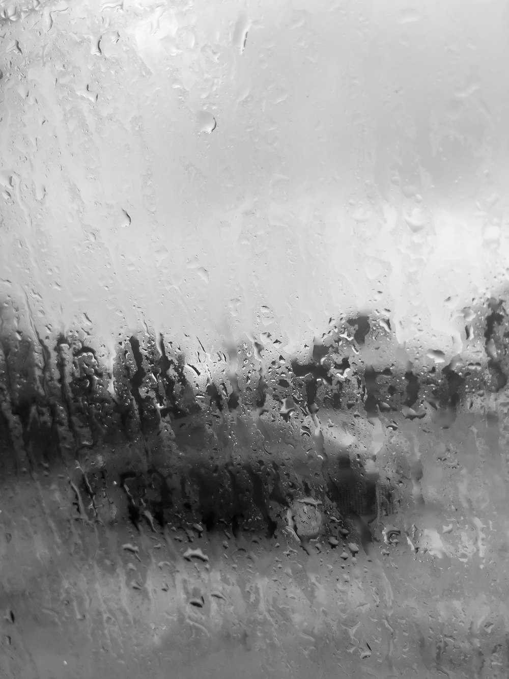 a black and white photo of rain on a window