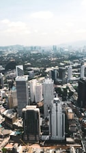 Aerial view of a modern cityscape showcasing various buildings and green spaces.