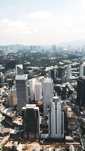 Aerial view of a modern cityscape showcasing various buildings and green spaces.