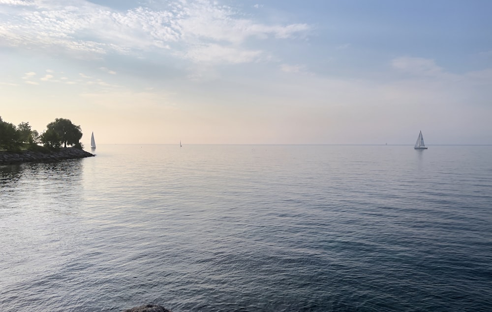 a sailboat is out on the water near the shore