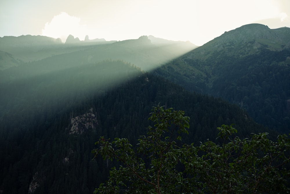 the sun shines through the clouds over the mountains