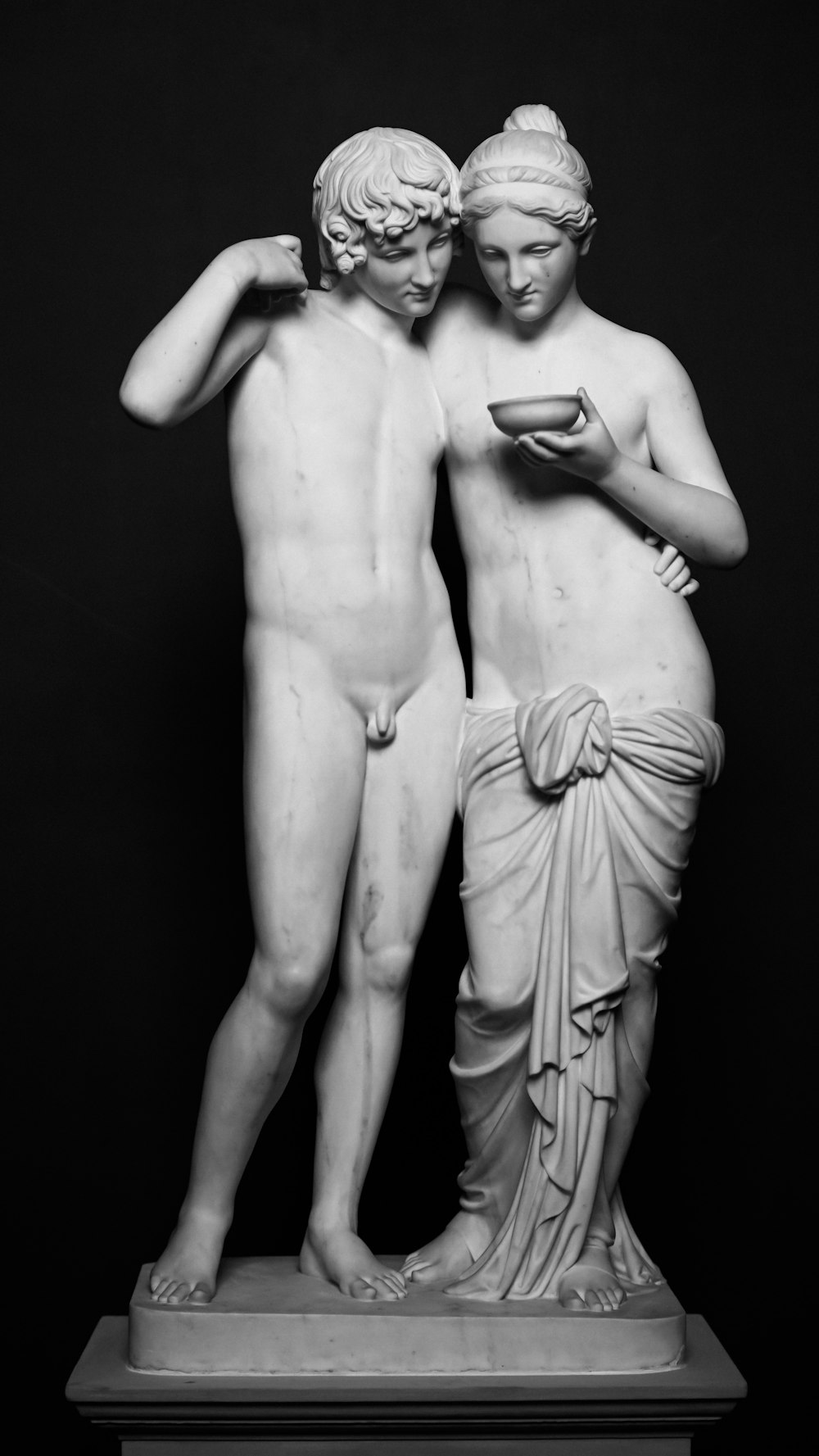 eine Statue von zwei Männern, die einen Becher halten