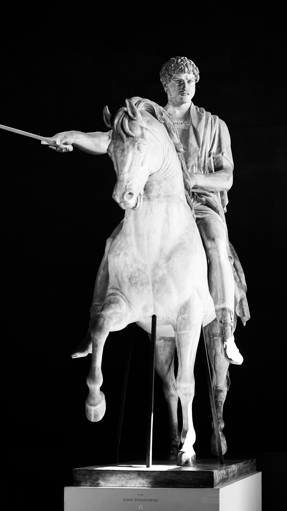 Ein Schwarz-Weiß-Foto einer Statue eines Mannes auf einem Pferd