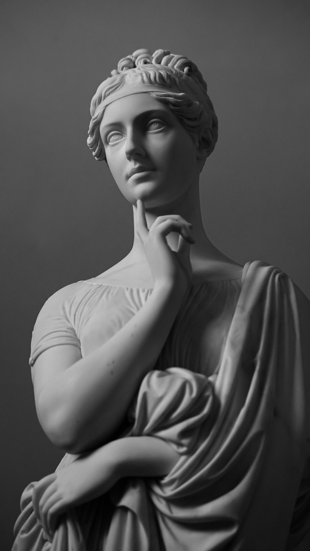 a black and white photo of a statue of a woman