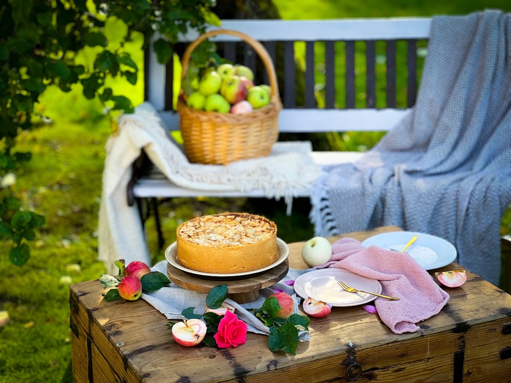 a table topped with a cake next to a basket of fruit