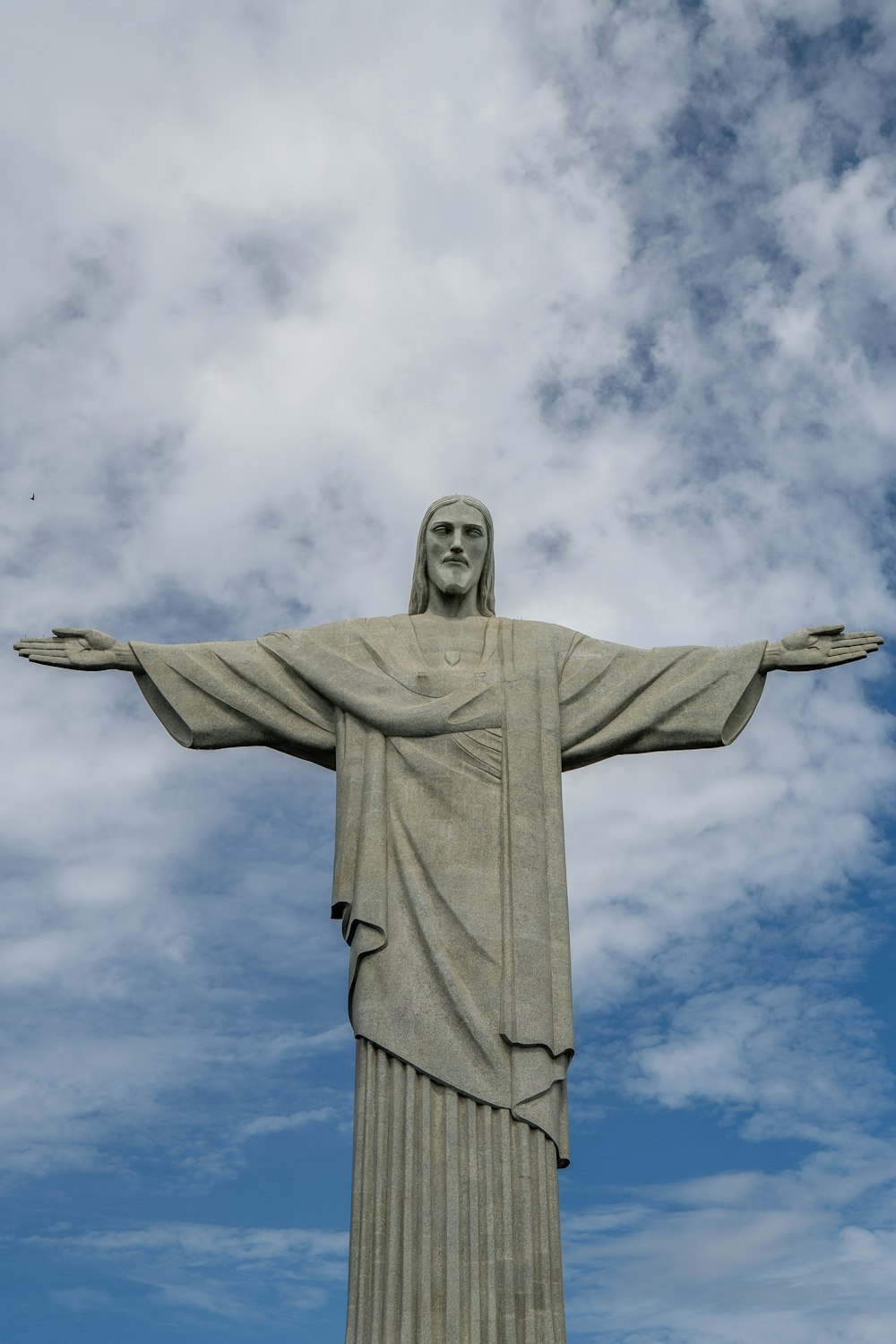 a statue of jesus with a sky background