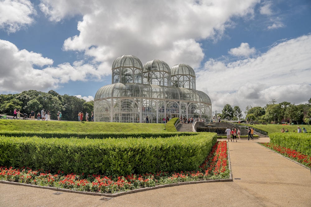 a garden with a large glass building in the middle of it