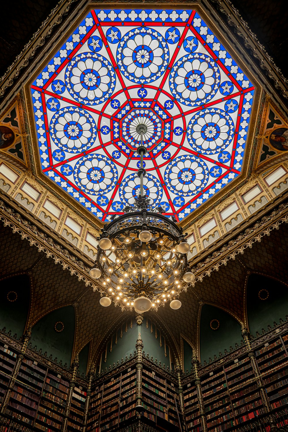 the ceiling of a library with a chandelier and bookshelves