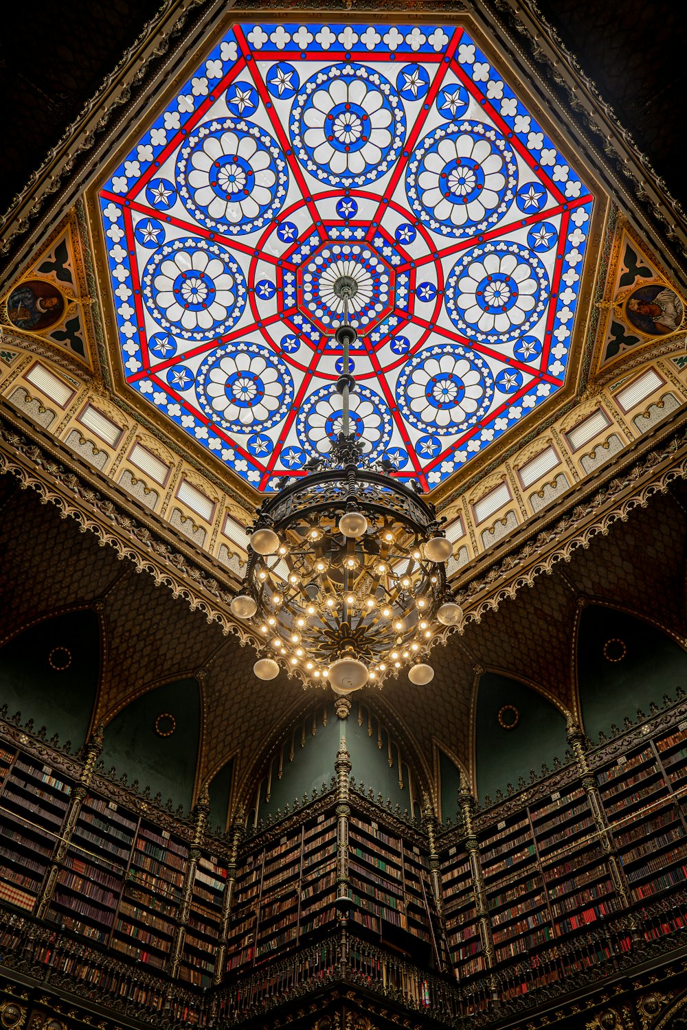 the ceiling of a library with a chandelier and bookshelves