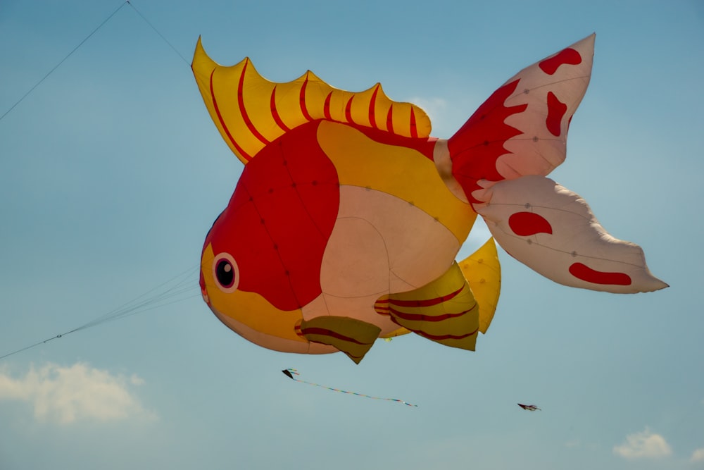 a large kite shaped like a fish flying in the sky