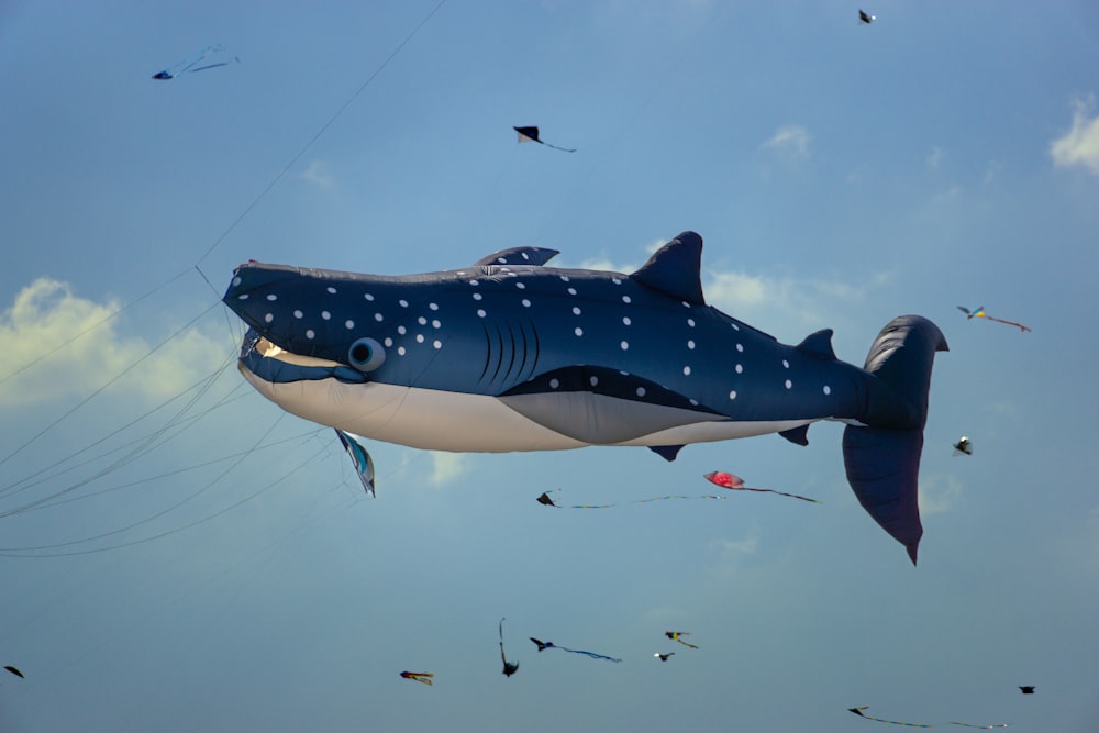 a large inflatable shark kite flying in the sky