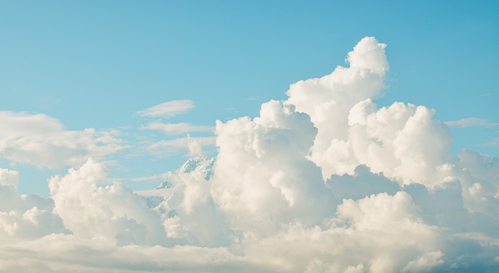 a plane flying through a cloud filled sky