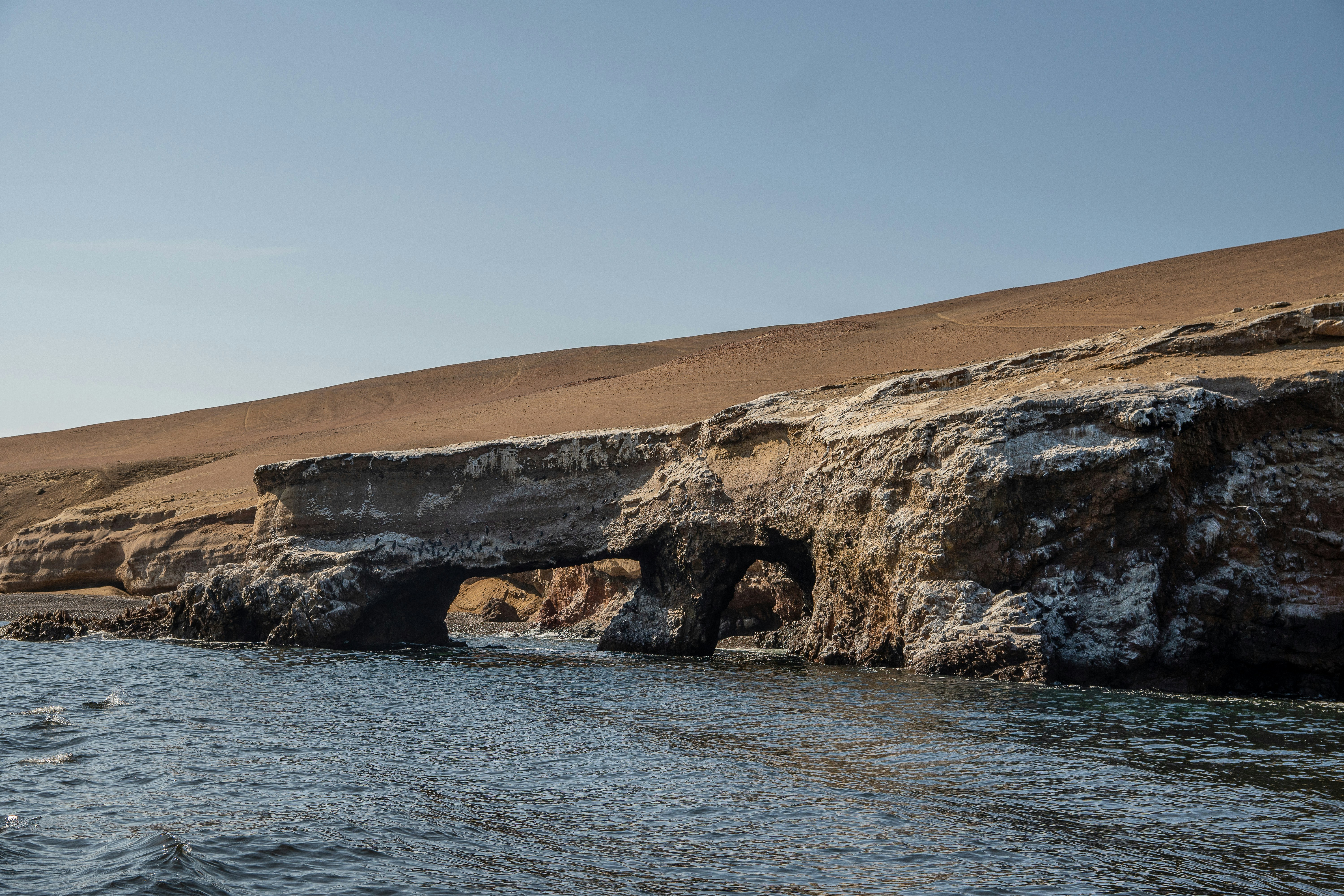 a large rock formation in the middle of a body of water