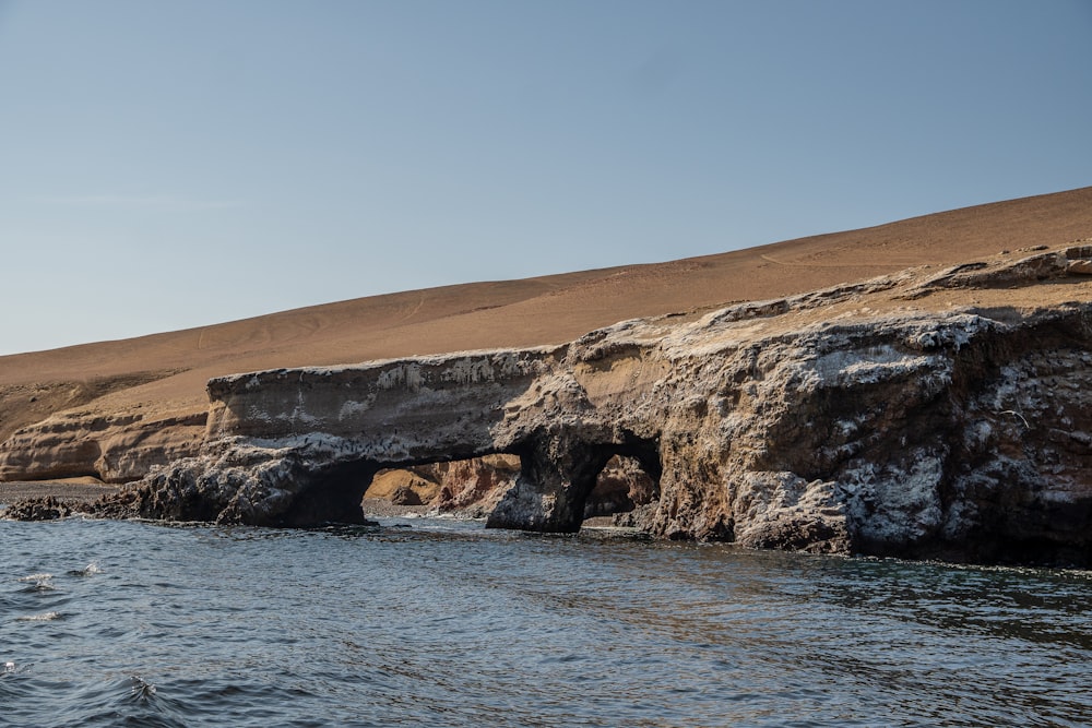 a large rock formation in the middle of a body of water