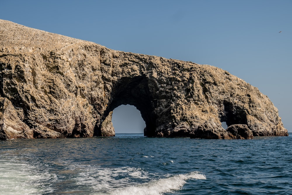 a large rock formation in the middle of a body of water