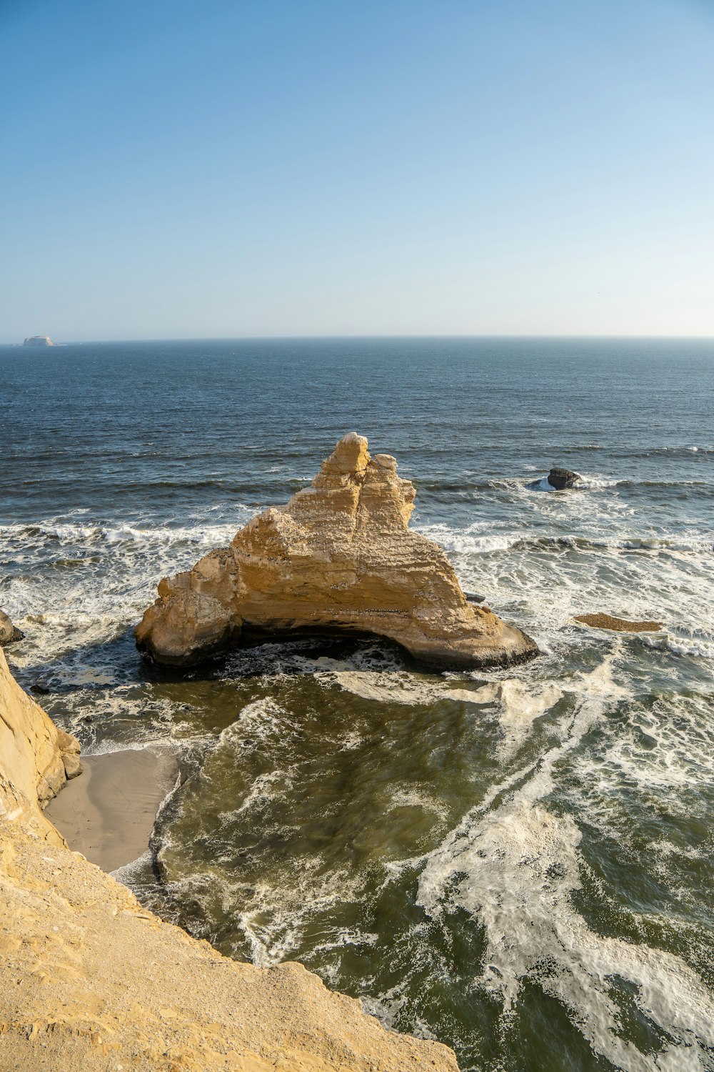 a large rock sticking out of the ocean