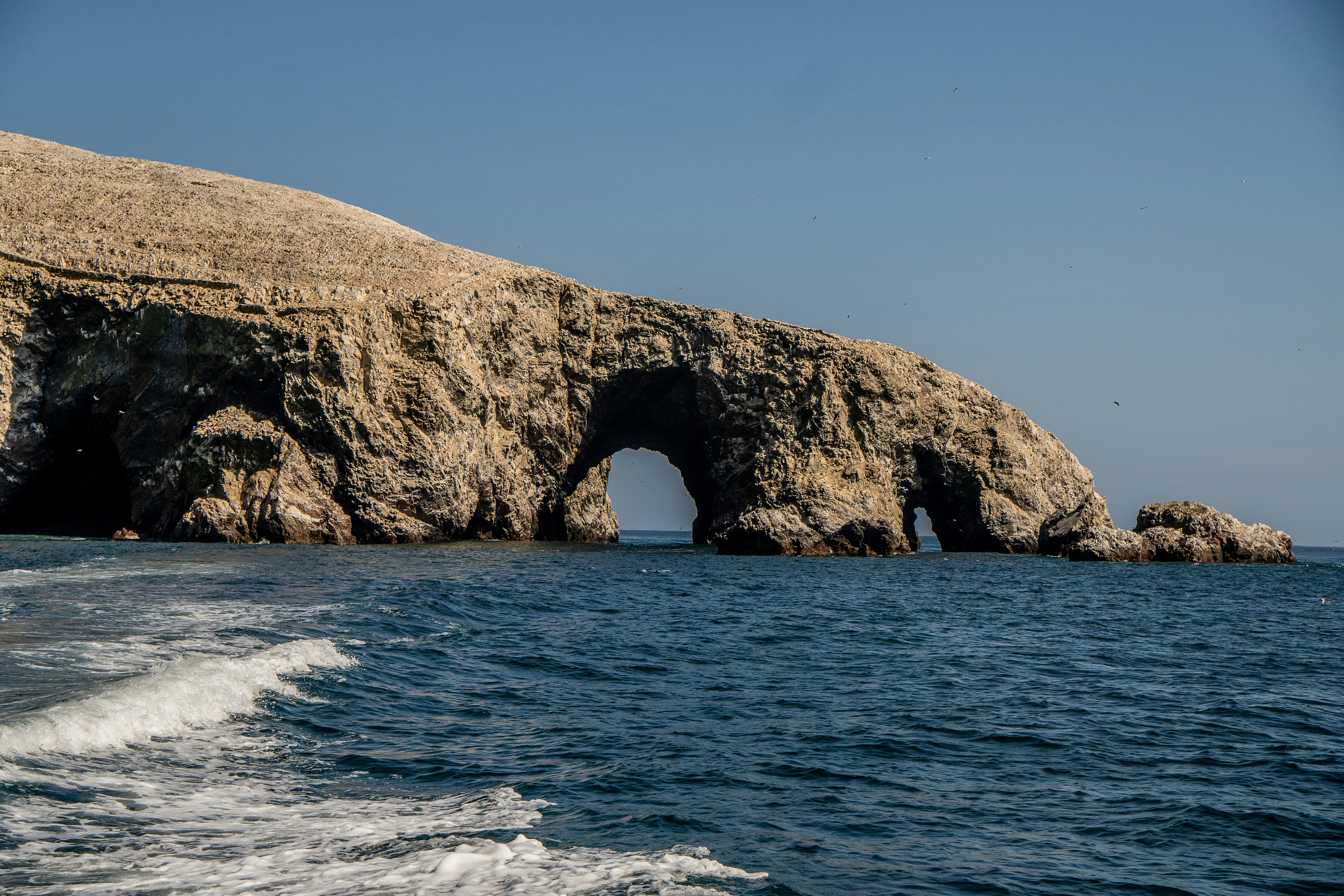 a large rock formation in the middle of a body of water