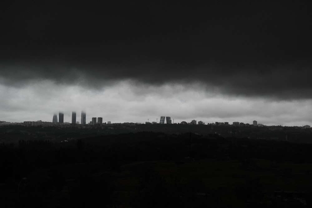 a black and white photo of a city under a cloudy sky