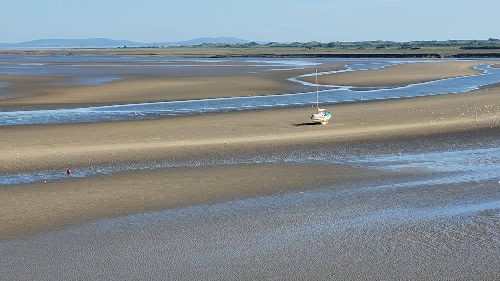 a small boat is sitting on the beach