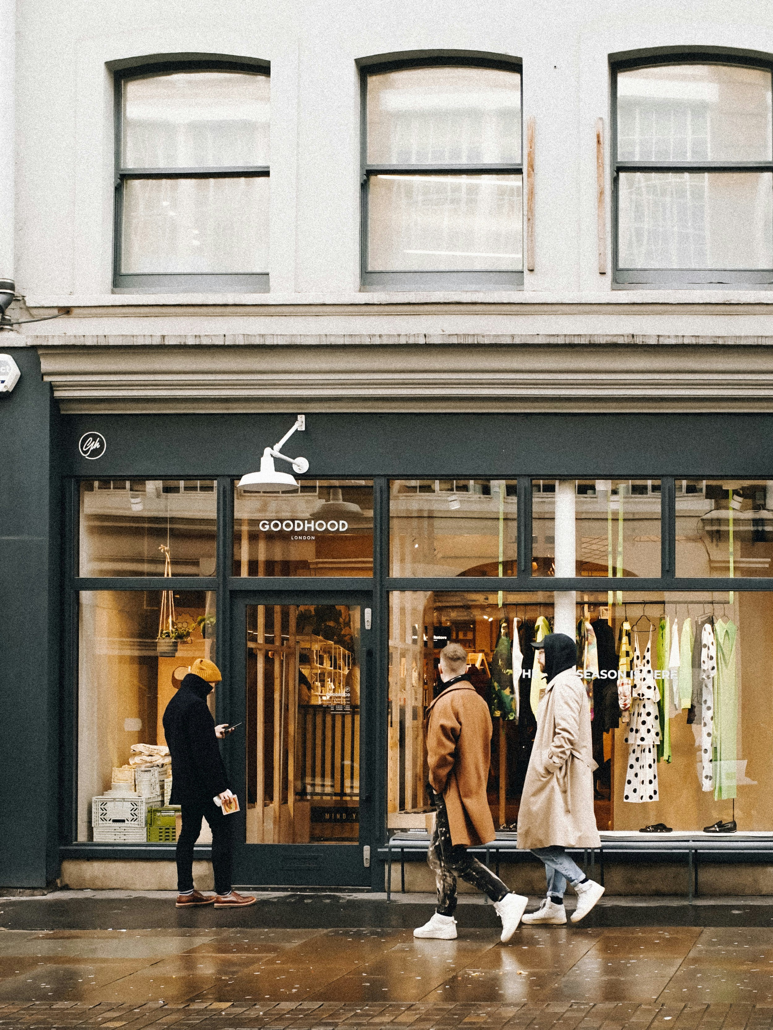 a couple of people that are walking by a store