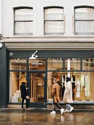 a couple of people that are walking by a store