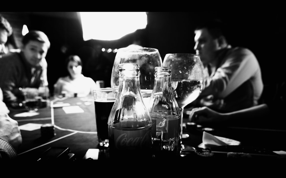 Un grupo de personas sentadas alrededor de una mesa con copas de vino