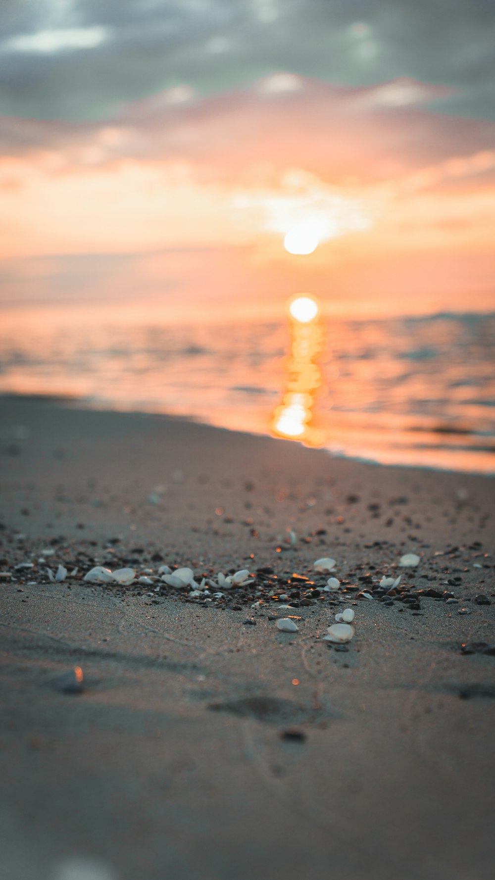 the sun is setting over the ocean on the beach