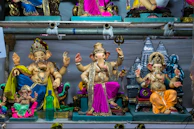 Elegant display of finished Ganpati idols on a minimalist shelf with soft gold and ivory backgrounds.