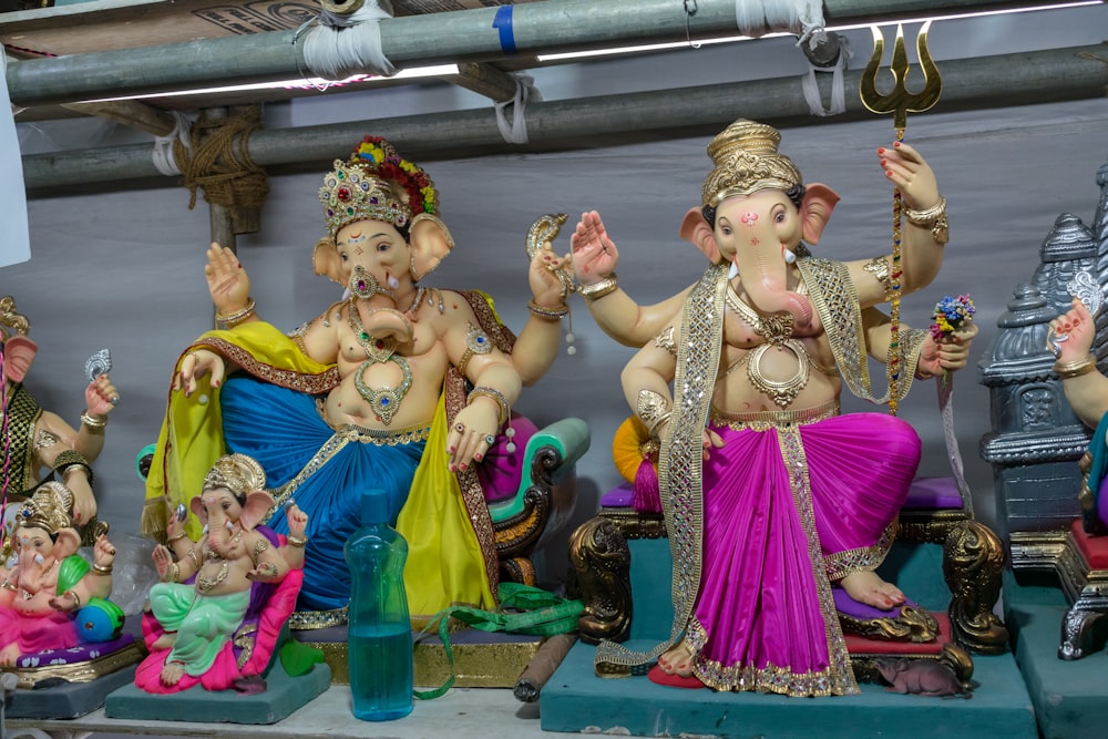 a group of statues of hindu deities on a shelf