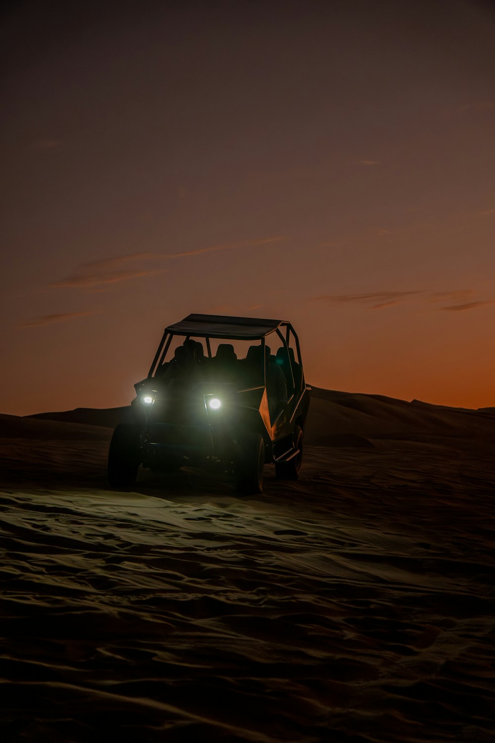 a jeep driving through the desert at night