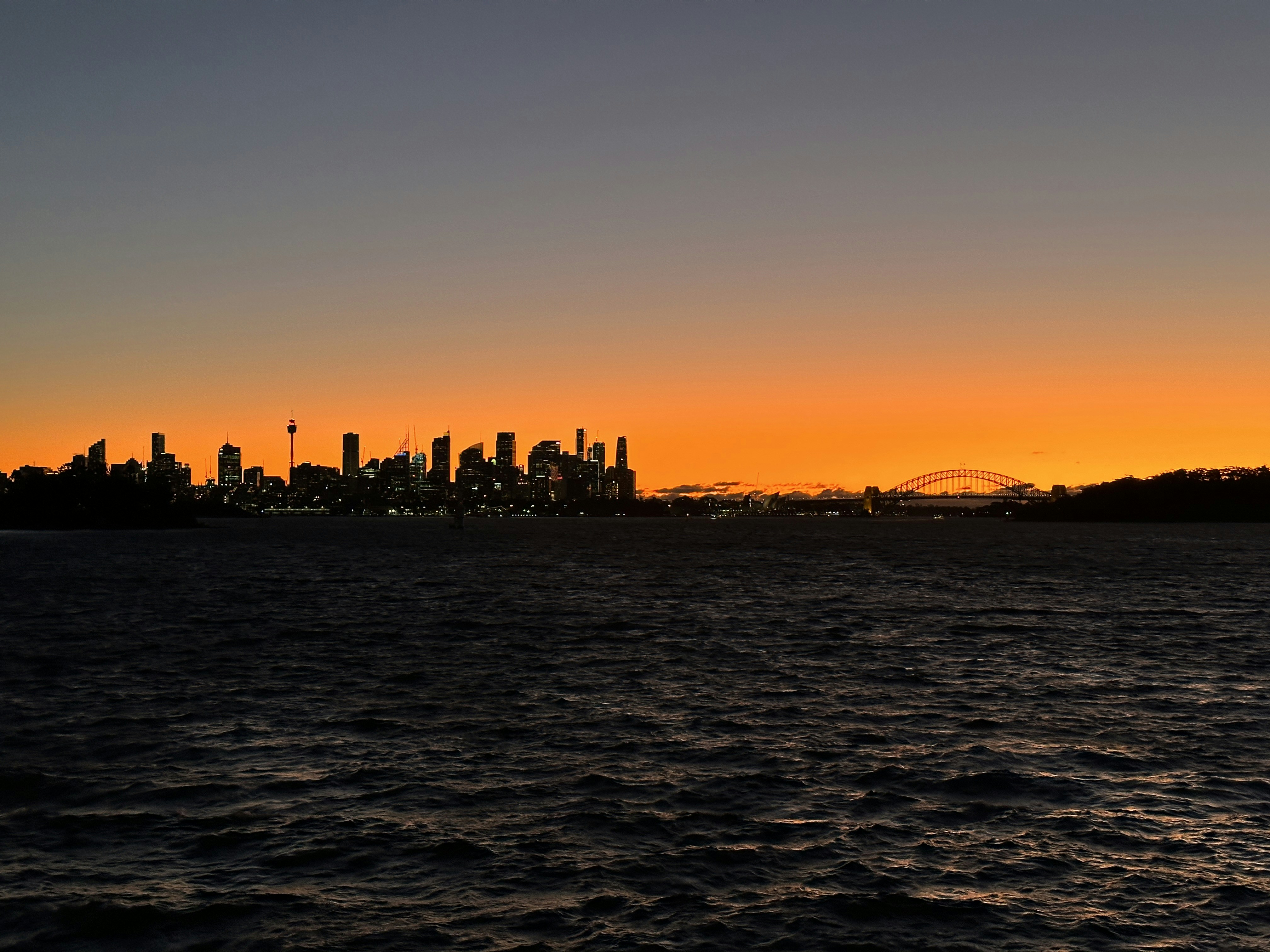 uma vista de uma cidade a partir da água ao pôr do sol