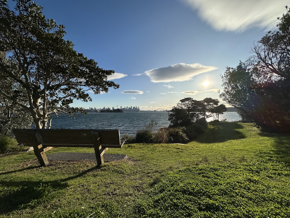 a wooden bench sitting on top of a lush green field