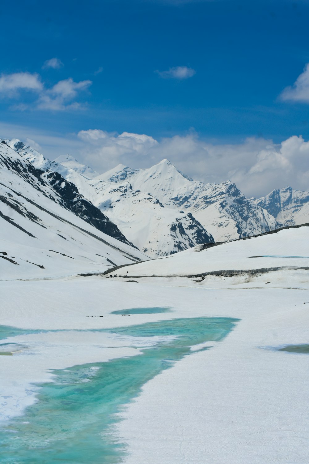 a stream of water running through a snow covered landscape