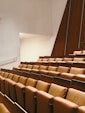 a row of brown chairs sitting in a room next to a wall