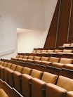 a row of brown chairs sitting in a room next to a wall