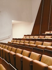 a row of brown chairs sitting in a room next to a wall