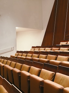 a row of brown chairs sitting in a room next to a wall