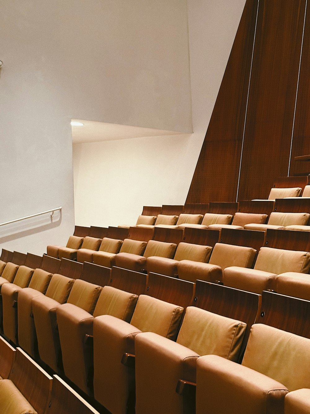 a row of brown chairs sitting in a room next to a wall